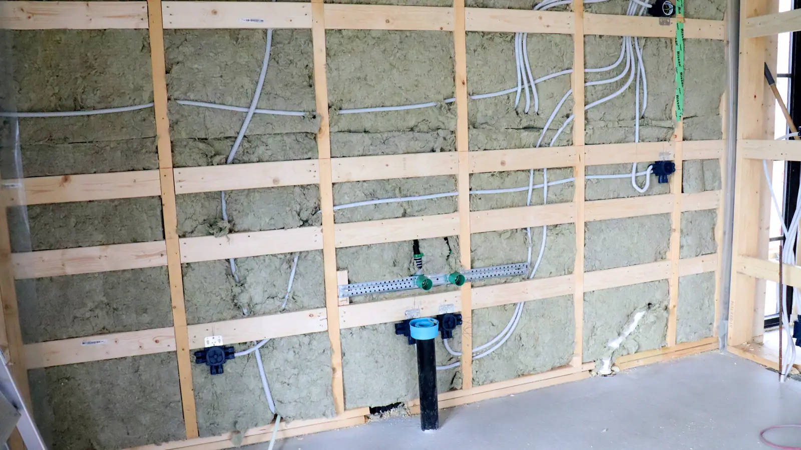 Timber-frame wall with insulation, conduits routed and installation boxes in position