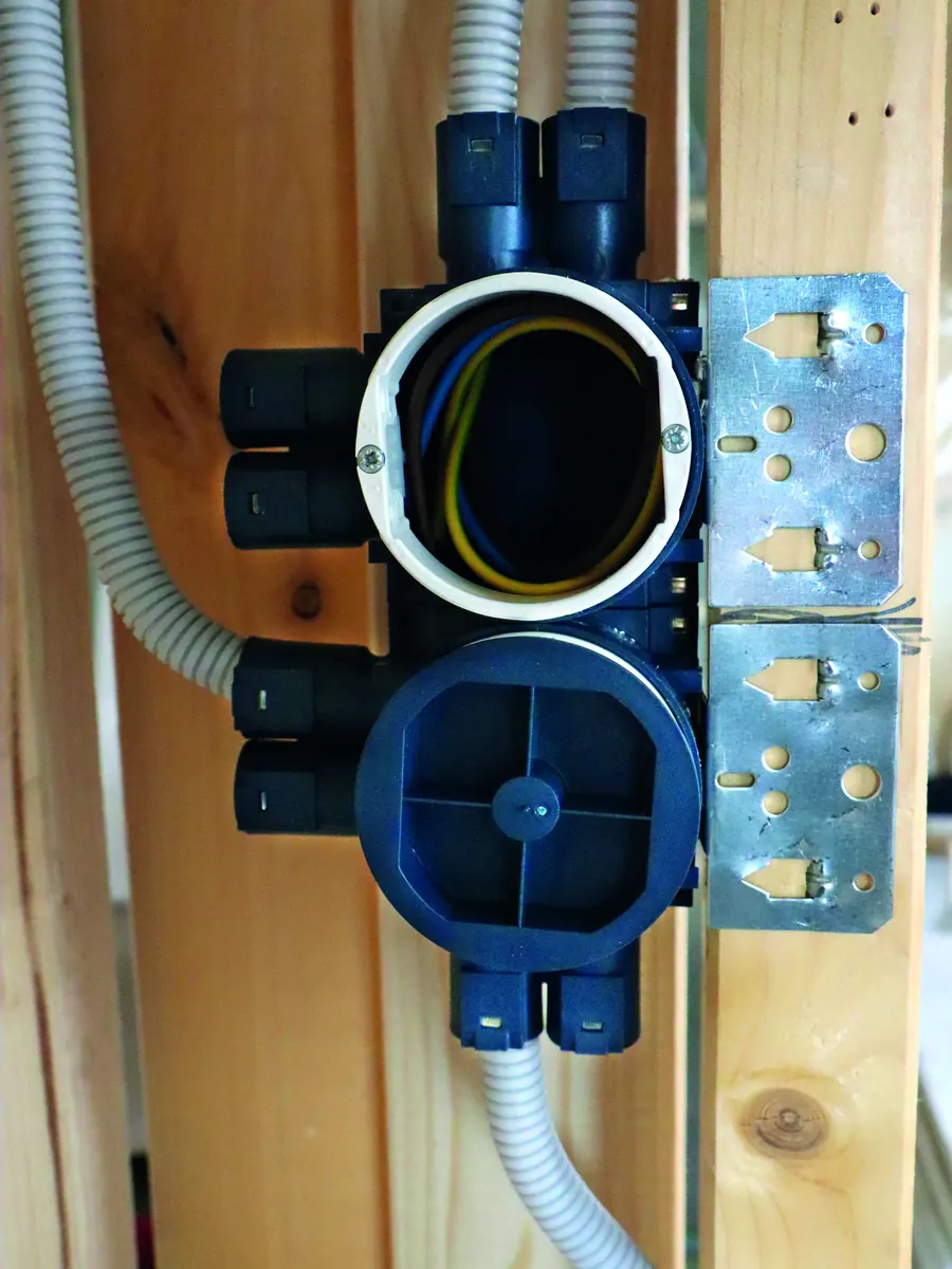 Stacked blue installation boxes on a timber stud with conduits entering from above and below