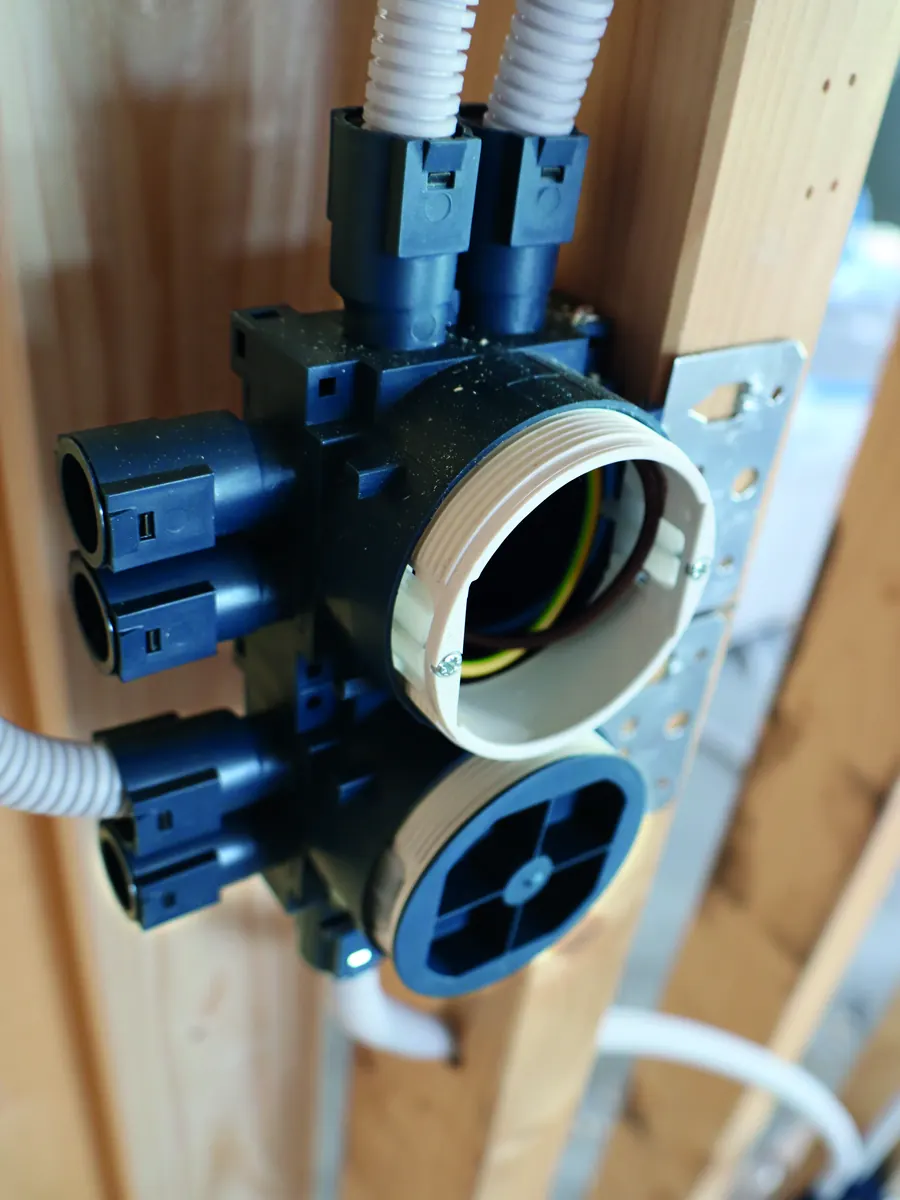 Blue gang installation box with side conduit entries fixed to a stud with a steel bracket
