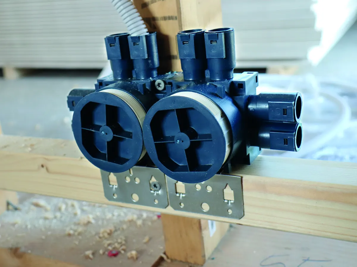 Two blue installation boxes fixed side by side on a horizontal batten with conduits connected