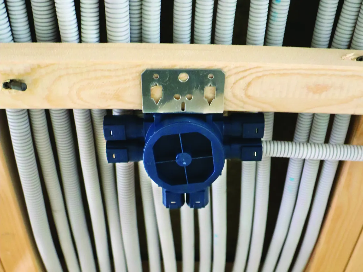 Ceiling element with a blue installation box fixed to a batten between rows of conduit