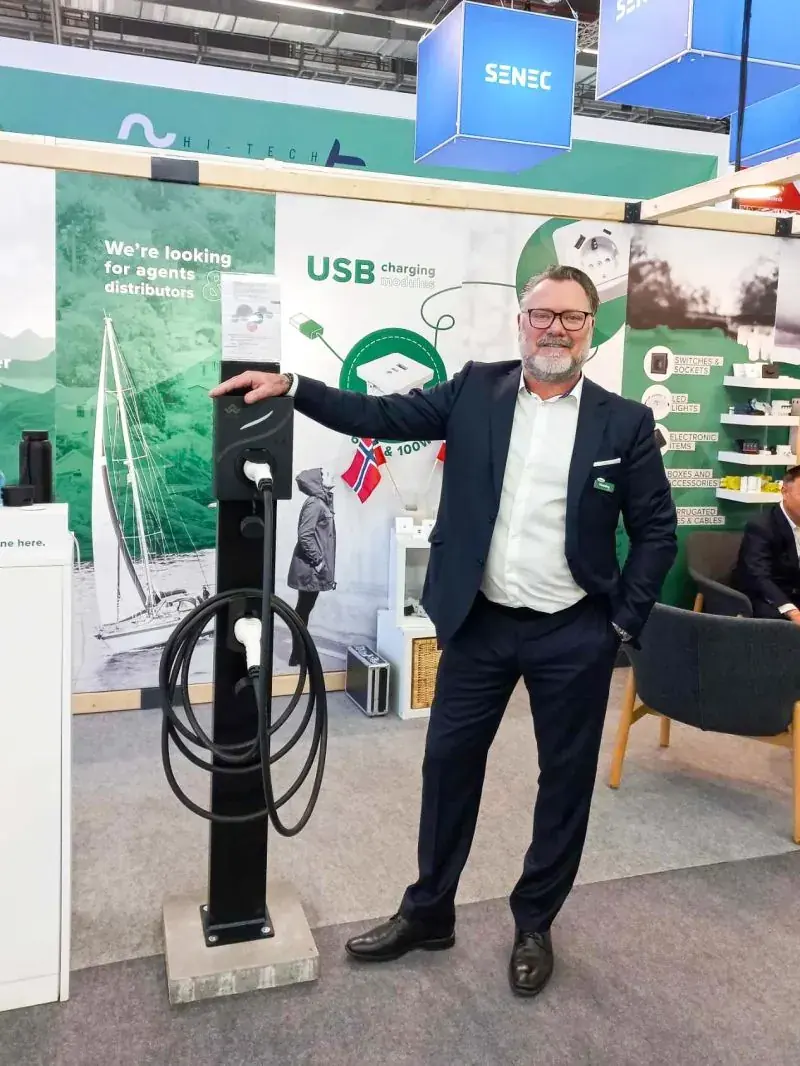 Glob-el representative presenting a USB charging module display stand to a visitor at Light + Building