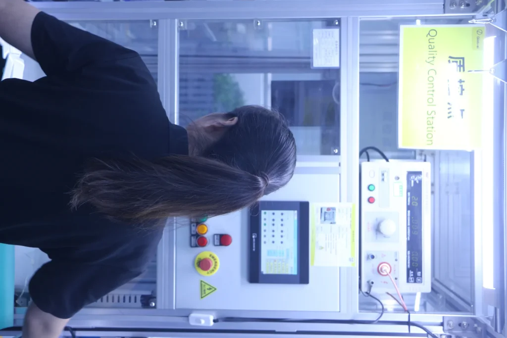 A Quality Control Station with high-voltage and leakage current testing equipment, operator checking results from behind